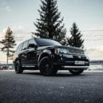 Odporność baterii na zimę w SUV-ach premium co sprawdzić przed zakupem i jak dbać o zasięg Czarny SUV premium zaparkowany na malowniczej drodze w górach