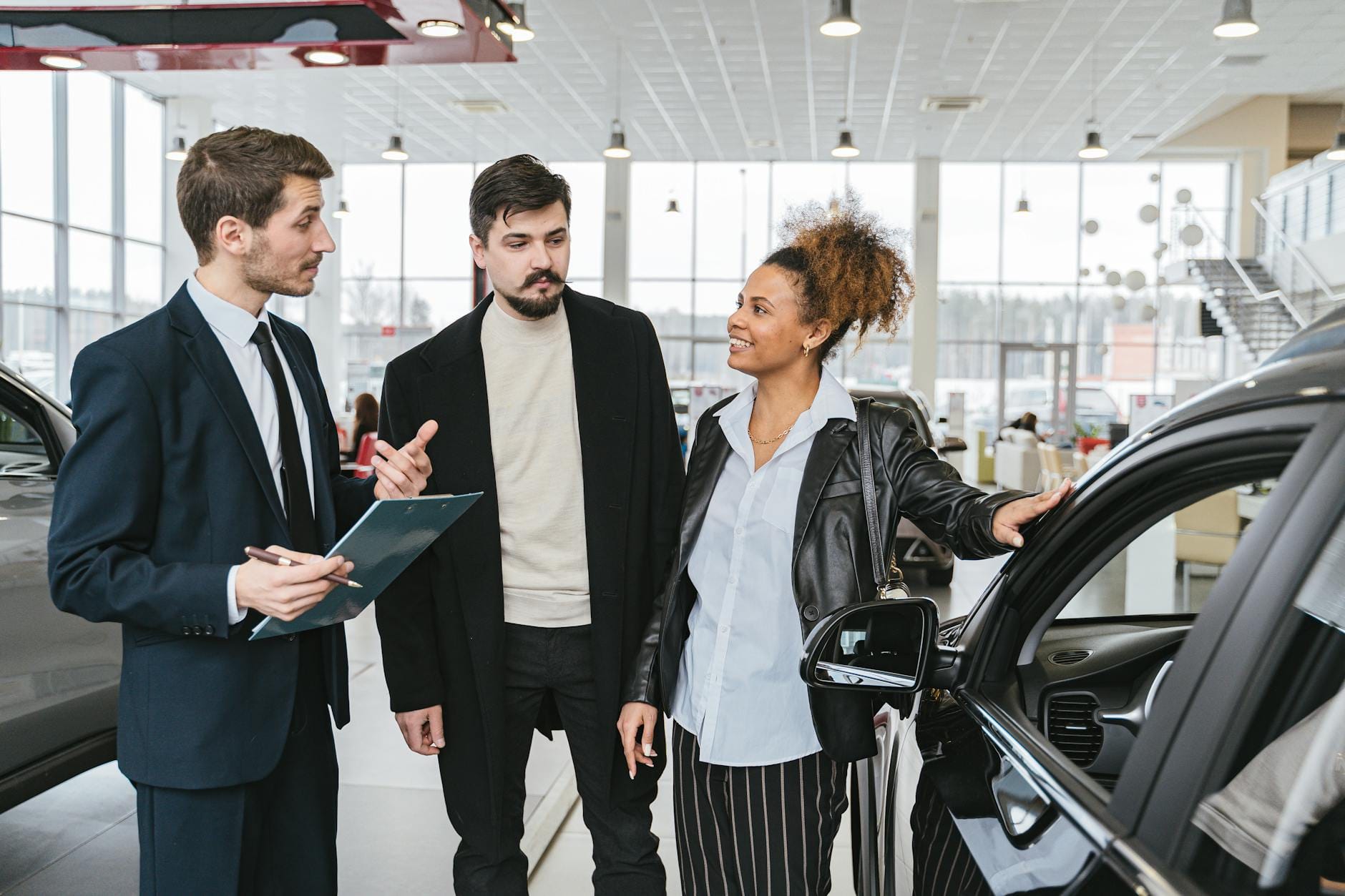 Klienci omawiają zakup auta premium z doradcą w salonie