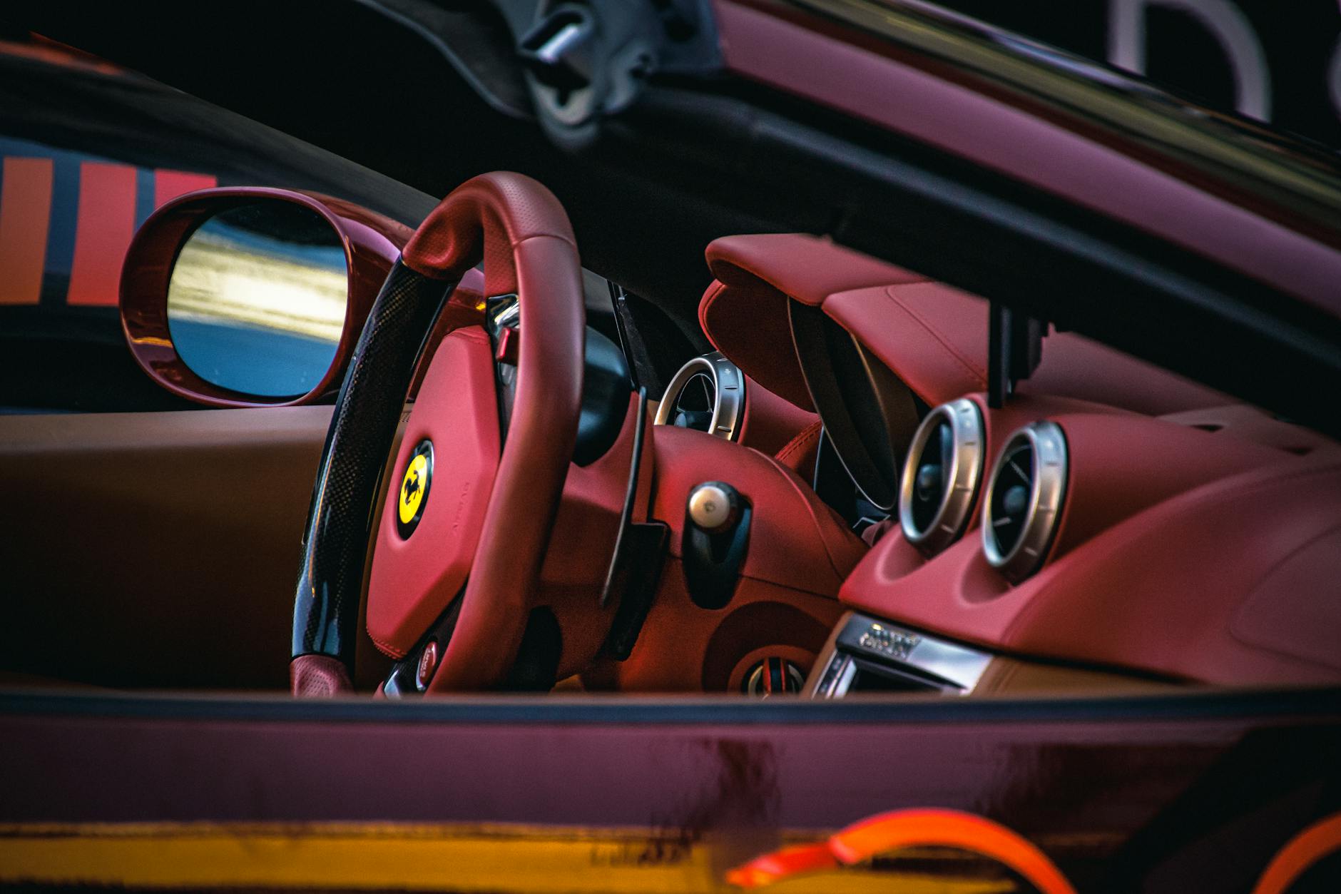 Wnętrze auta premium z czerwonymi, sportowymi fotelami i kierownicą