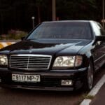 Jak nie zniszczyć felg na krawężnikach: miejskie triki dla aut premium Czarny Mercedes klasy premium zaparkowany na ulicy w słoneczny dzień