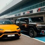 Jak przygotować luksusowego SUV-a do track day bez utraty komfortu Pomarańczowe Lamborghini i czarny SUV zaparkowane na torze wyścigowym