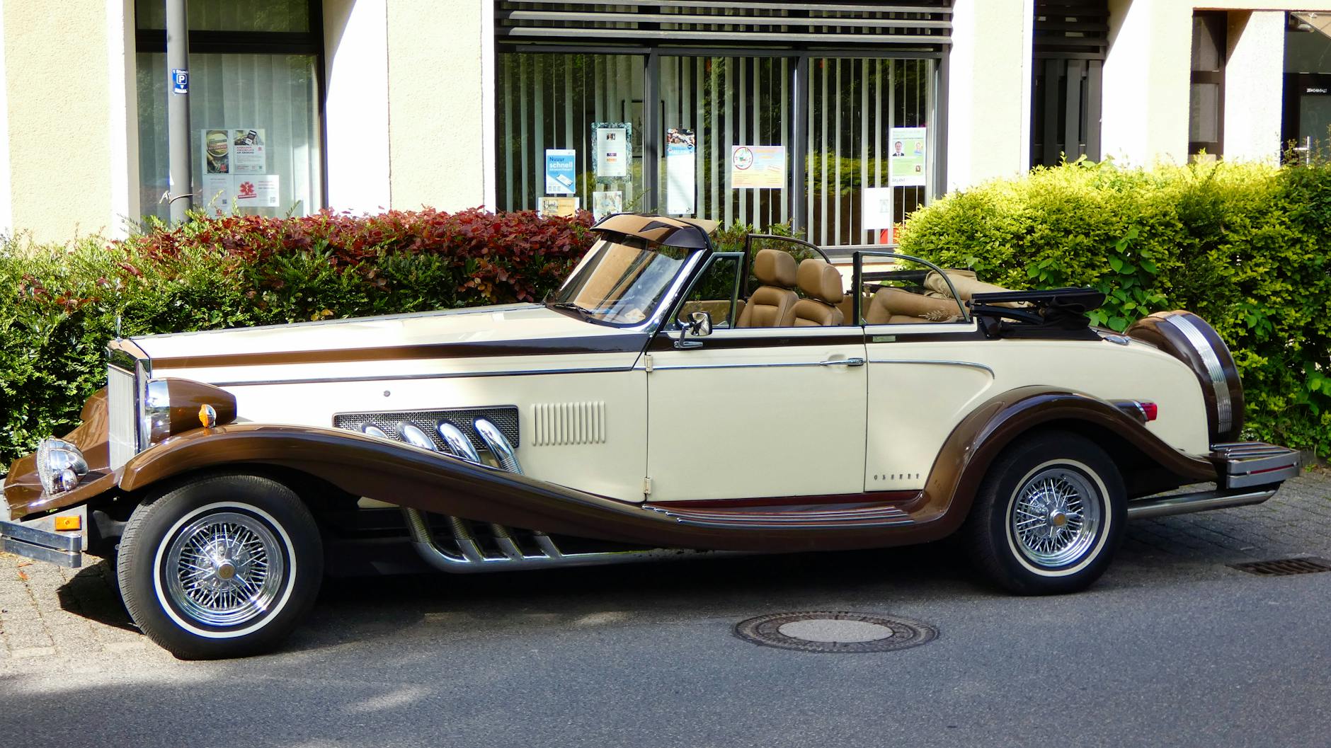 Zabytkowy kabriolet z chromowanymi felgami zaparkowany przy ulicy