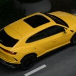 Range Rover Velar: design, który uczynił z minimalizmu nowy luksus Żółty luksusowy SUV o minimalistycznym designie zaparkowany na ulicy Bangkok