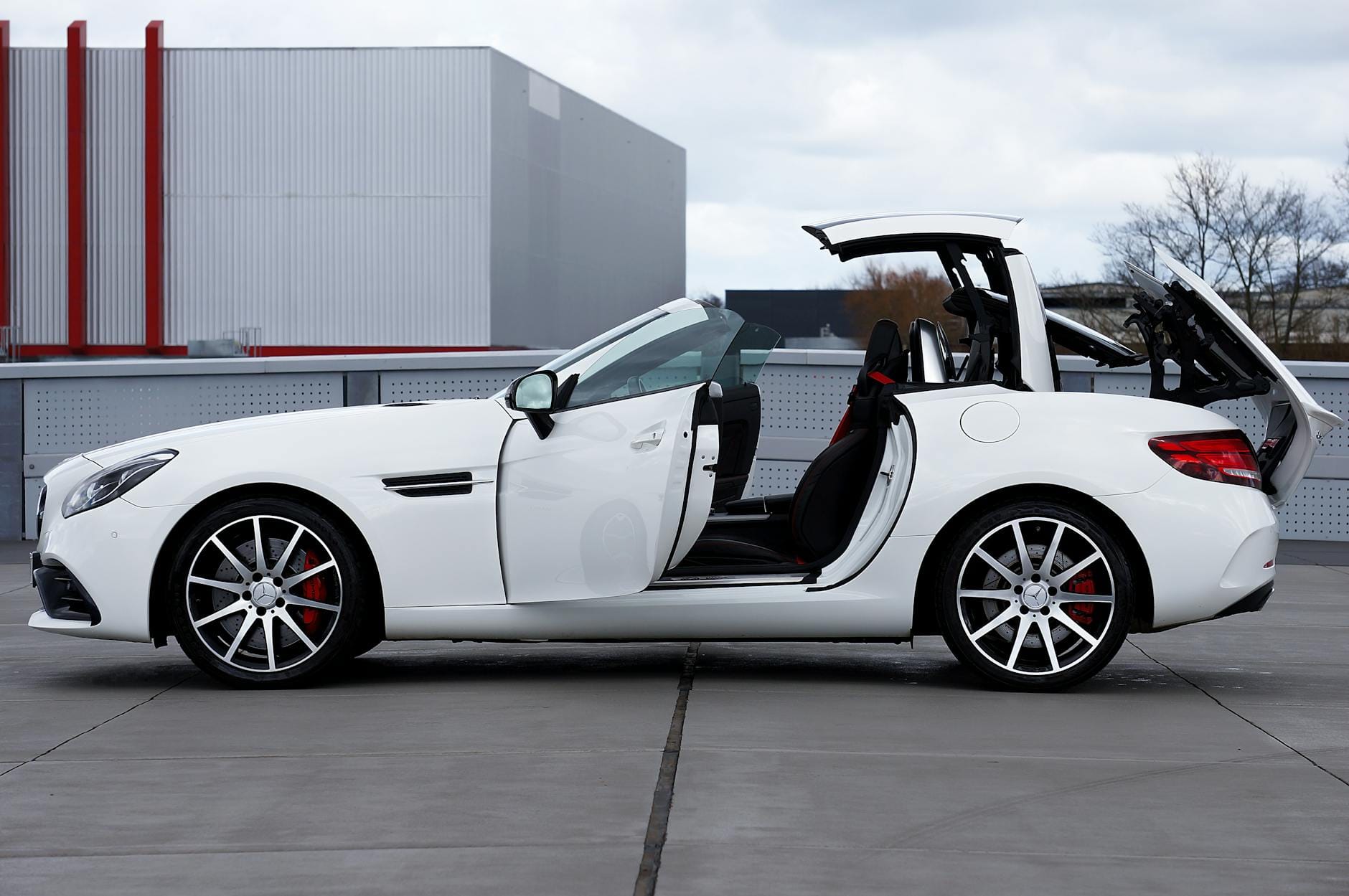 Mienie przesiedleńcze: odmowa urzędu skarbowego Białe nowoczesne cabrio z otwartym dachem na pustym parkingu na dachu