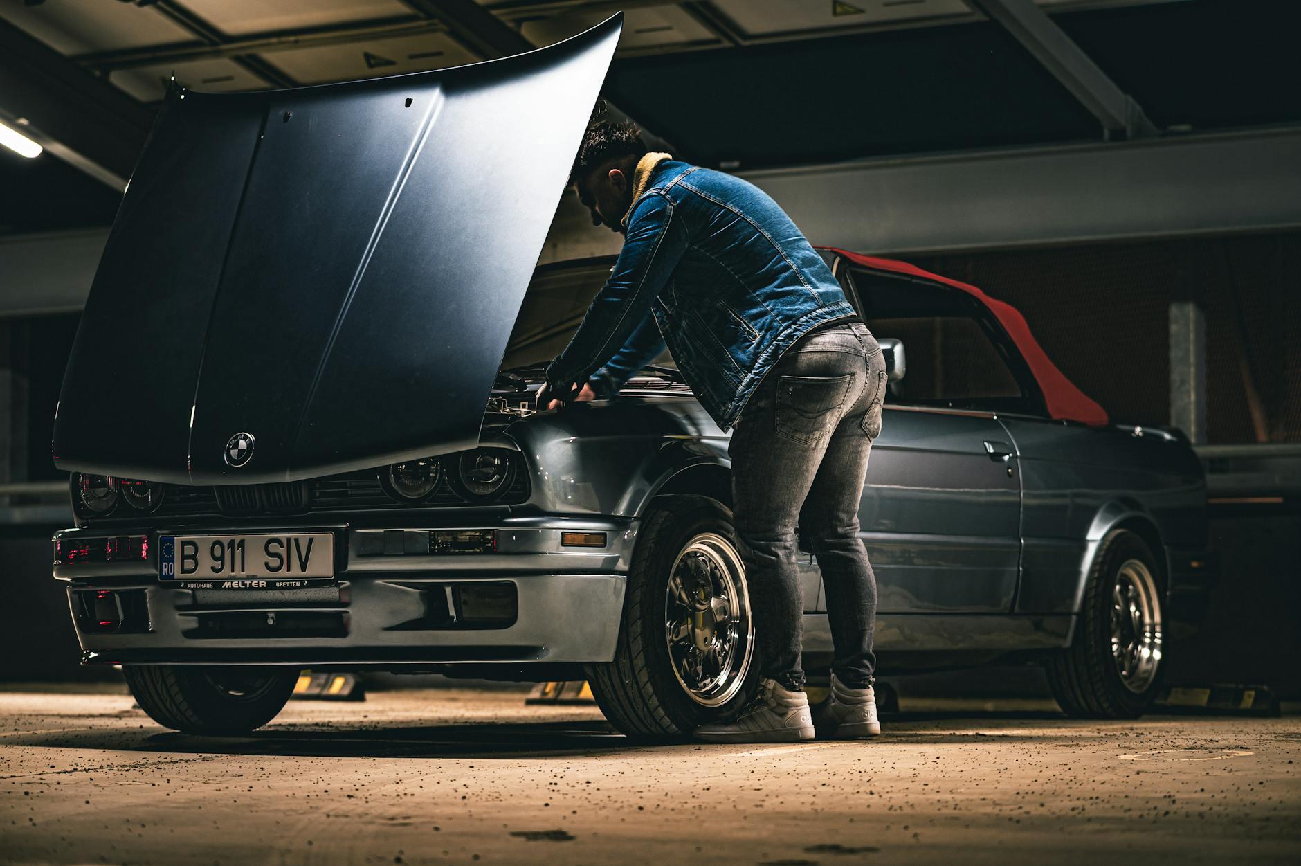 Mechanik sprawdza silnik kabrioletu w garażu