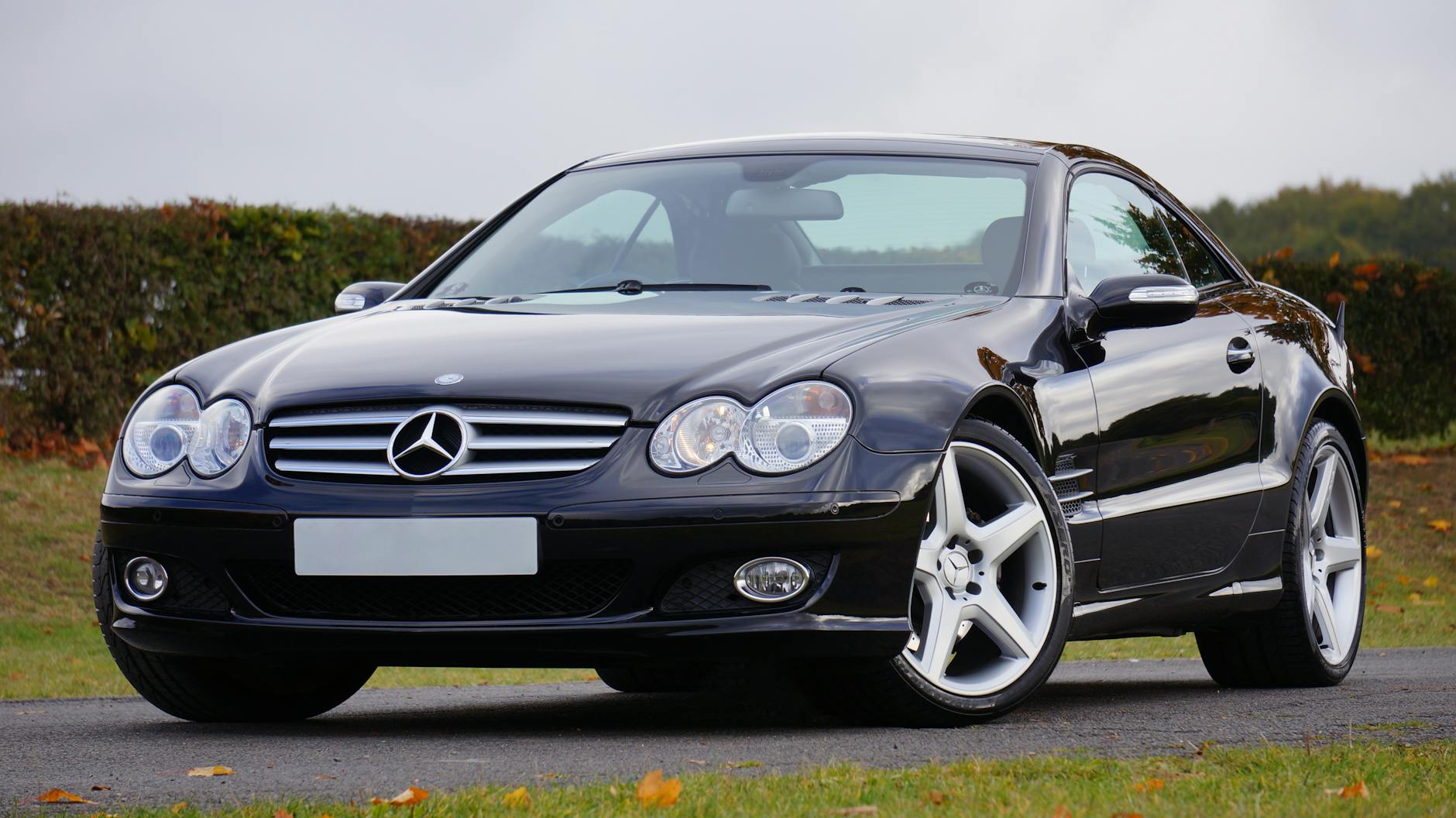 Czarny kabriolet Mercedes jedzie drogą w słoneczny dzień