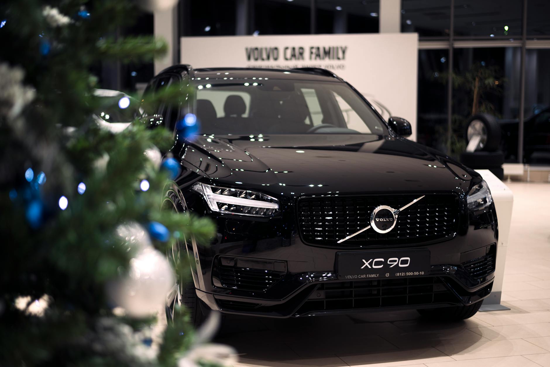 Czarny Volvo XC90 w świątecznie udekorowanym salonie samochodowym