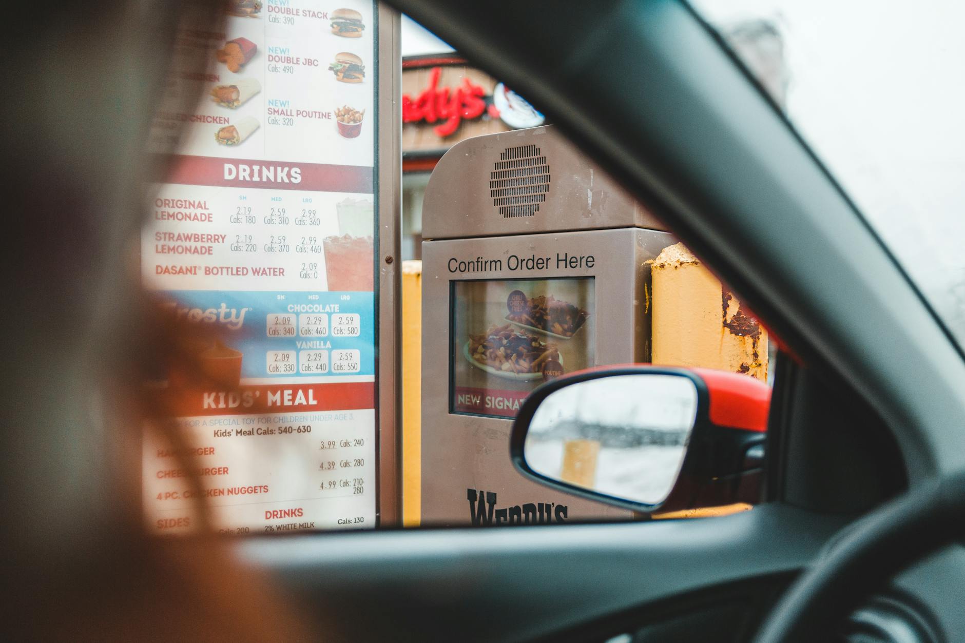 Kierowca składa zamówienie przy głośniku w kawiarni drive-thru