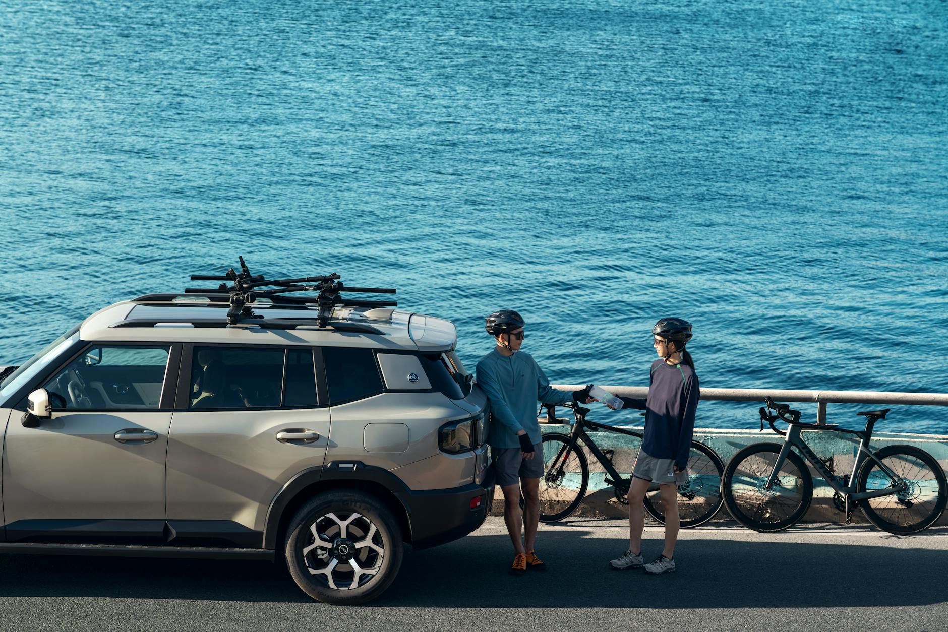Rowerzyści pakują sprzęt do SUV-a nad błękitnym oceanem