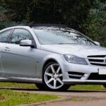 Coupe na weekend i do pracy top 7 modeli premium, które nie męczą na co dzień Srebrne coupe Mercedes-Benz zaparkowane przy spokojnej, zielonej drodze