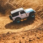SUV Land Rover jedzie dynamicznie po piaszczystych wydmach