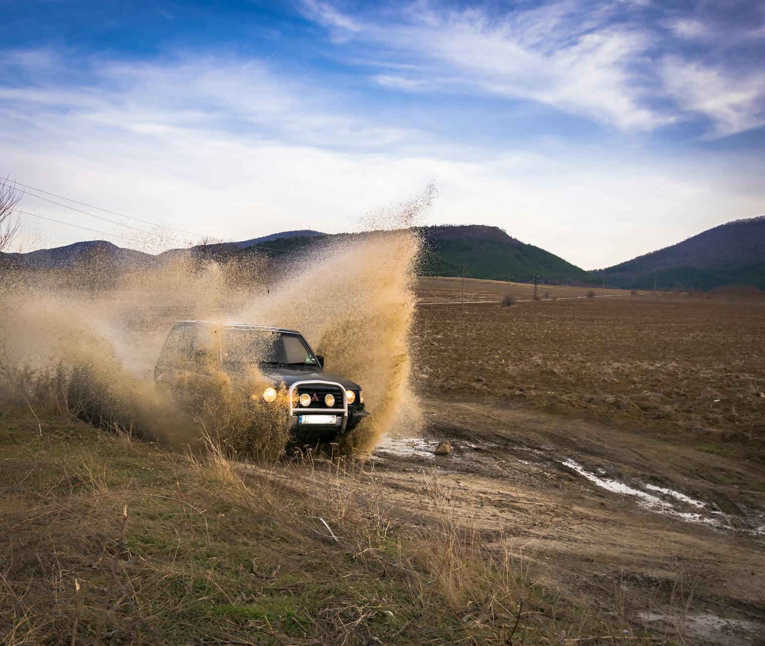 SUV Land Rover jedzie w błocie w terenie w Bułgarii