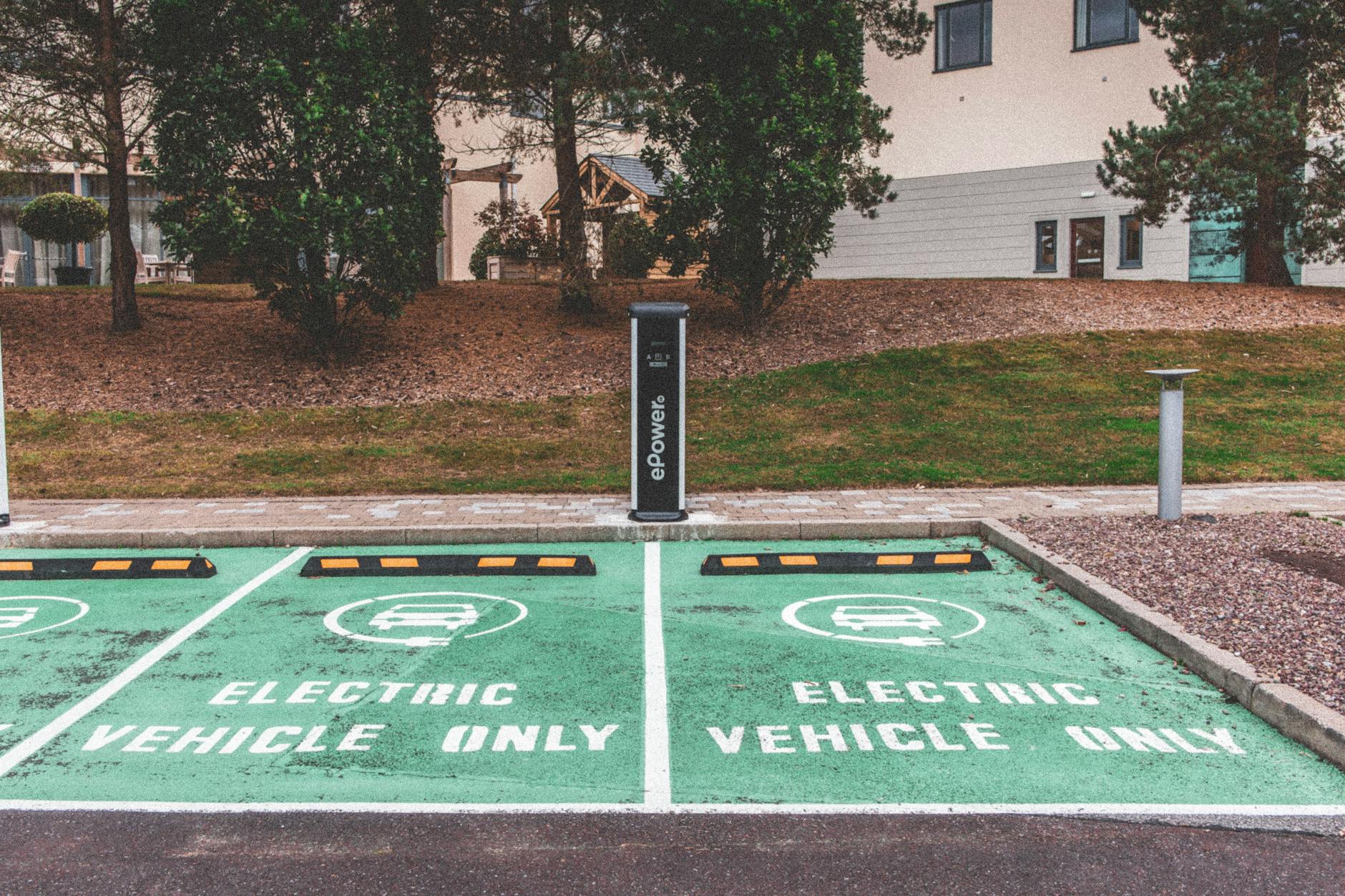 Zielony elektryczny samochód podłączony do ładowarki w mieście